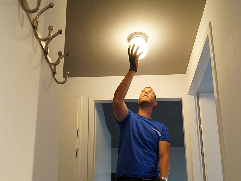 klusjesman hangt een lamp op